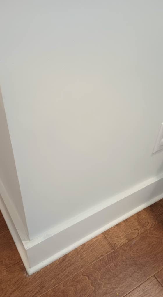 Repaired and painted wall with finished baseboard