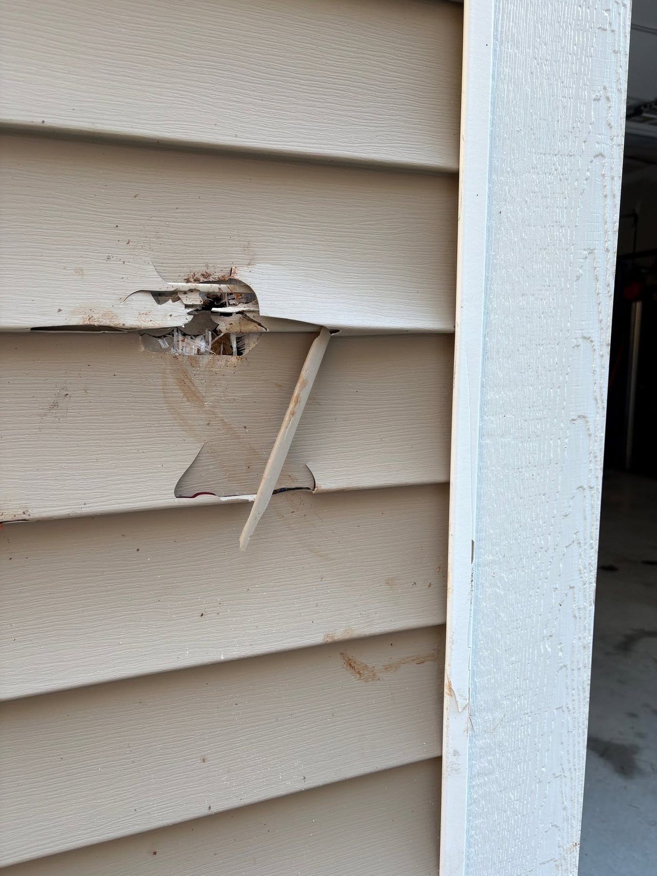 Damaged exterior vinyl siding before repair